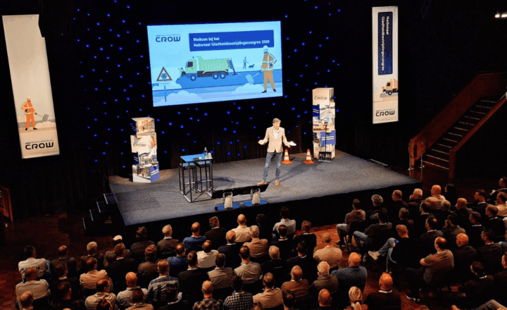 Hoofdpodium met dagvoorzitter en publiek