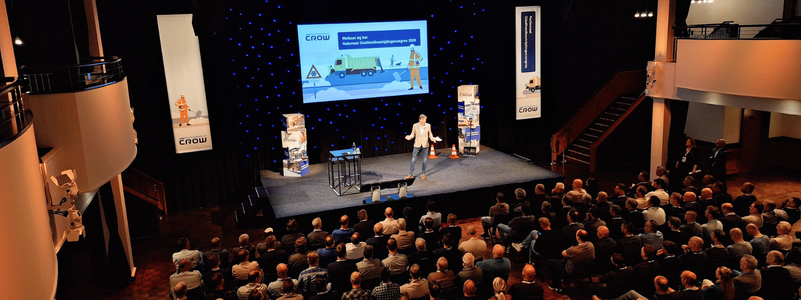 Hoofdpodium met dagvoorzitter en publiek